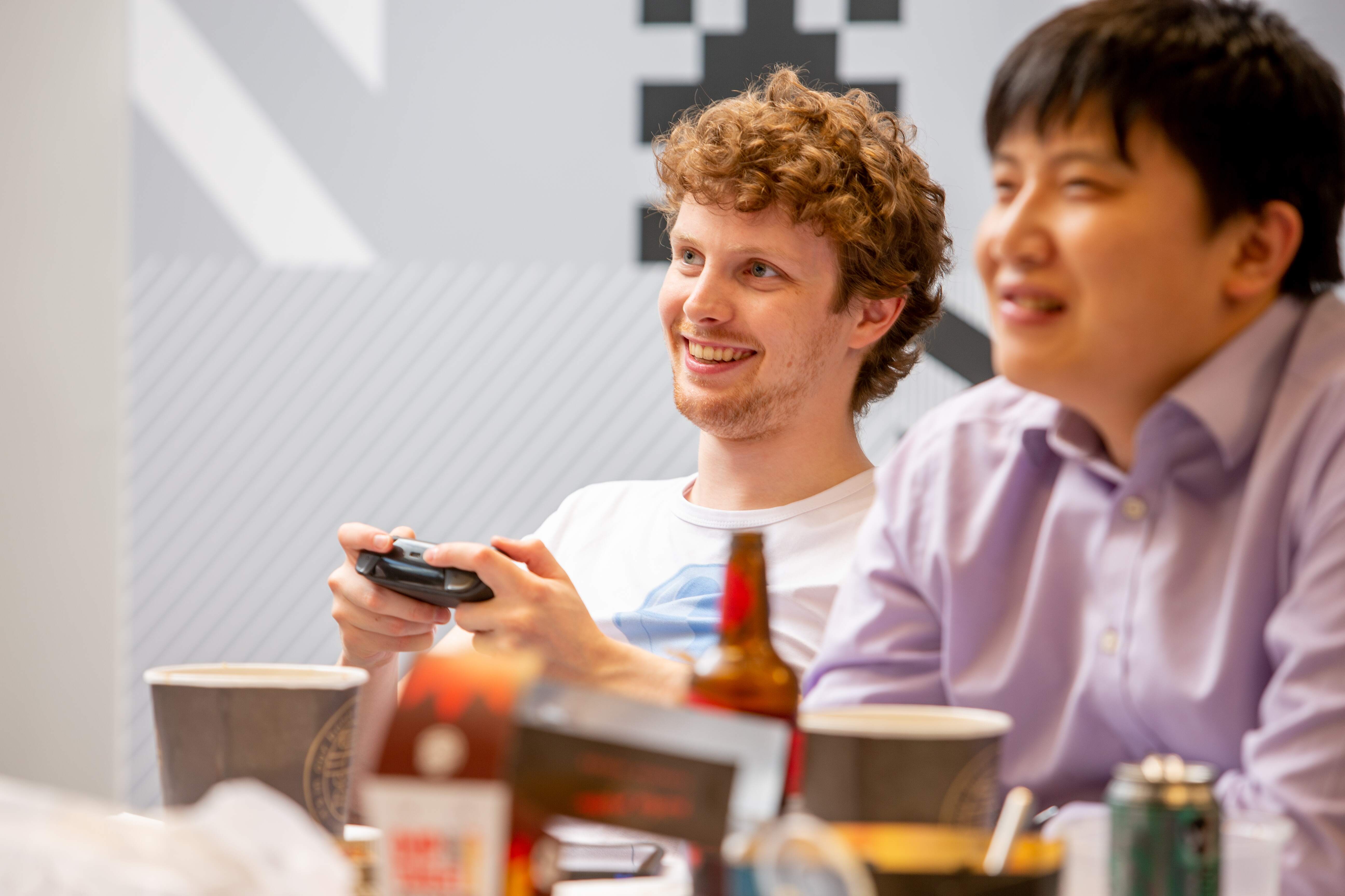 Thought Machine employees smiling whilst playing a video game
