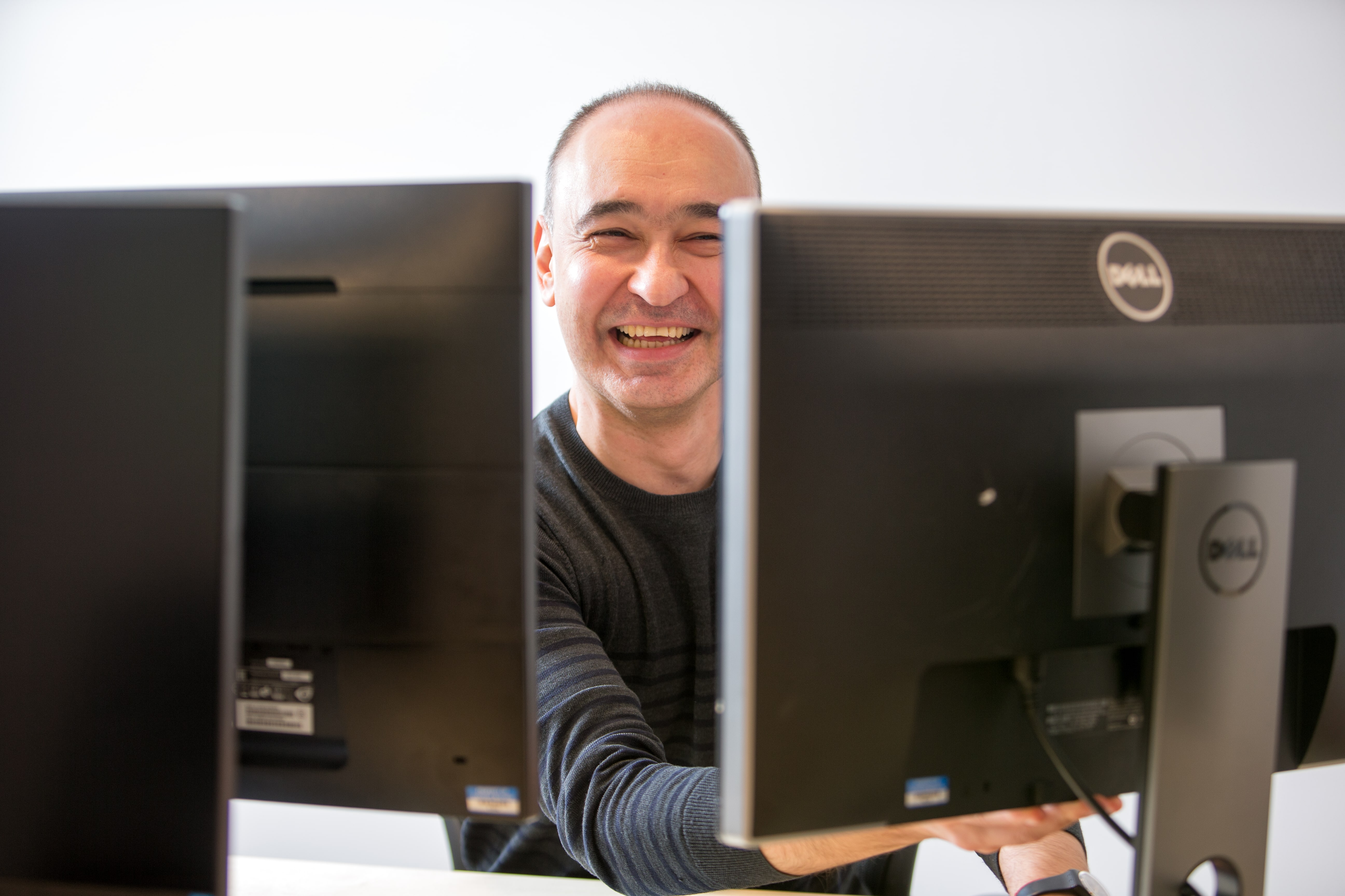 Thought machine employee smiling behind computer screens